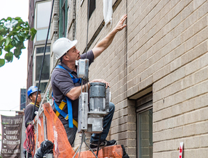 Hands-on Facade Inspection Safety Program (FISP) inspection by motorized scaffold in New York City.