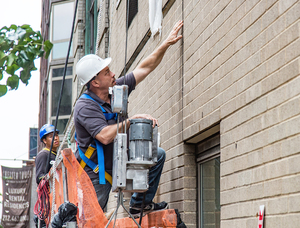 Hands-on Facade Inspection Safety Program (FISP) inspection by motorized scaffold in New York City.