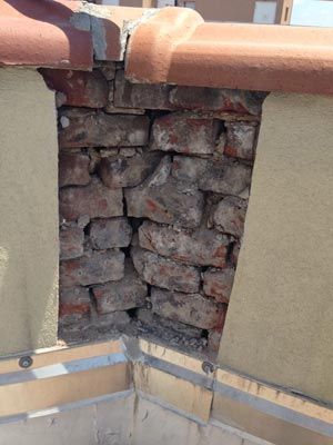 Investigative probes can uncover hidden defects, like this crumbling parapet wall concealed by stucco finish.